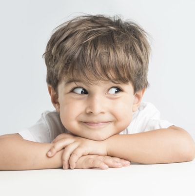 Little boy laying down and folding his arms while looking to the side