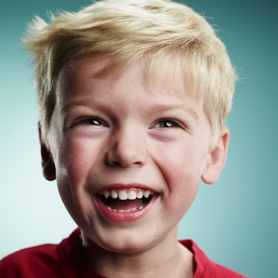 Close-up of a little blonde boy laughing