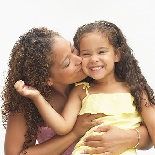 Mother kissing daughter on the cheek